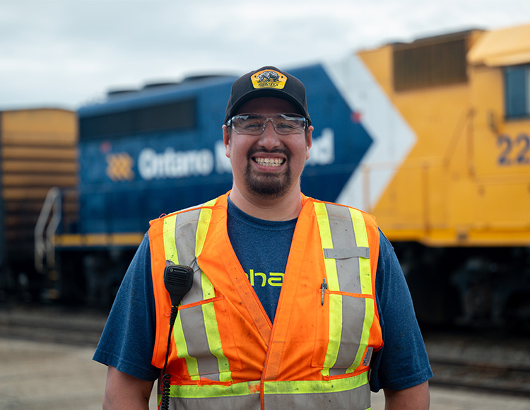 Man in orange vest smiling at the camera